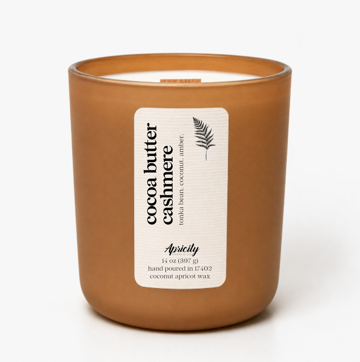 Cocoa Butter Cashmere 14 oz candle in a frosted caramel tumbler with a cream fern label reading tonka bean, coconut, amber