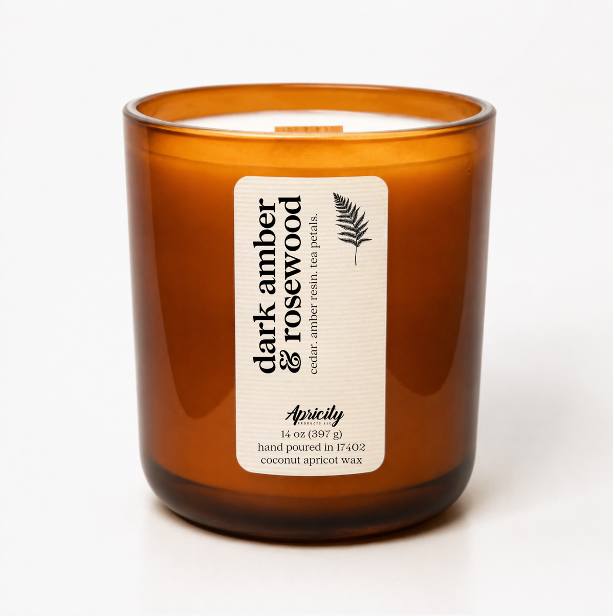 Dark Amber & Rosewood candle in an amber glass tumbler with a wooden wick and cream Apricity label