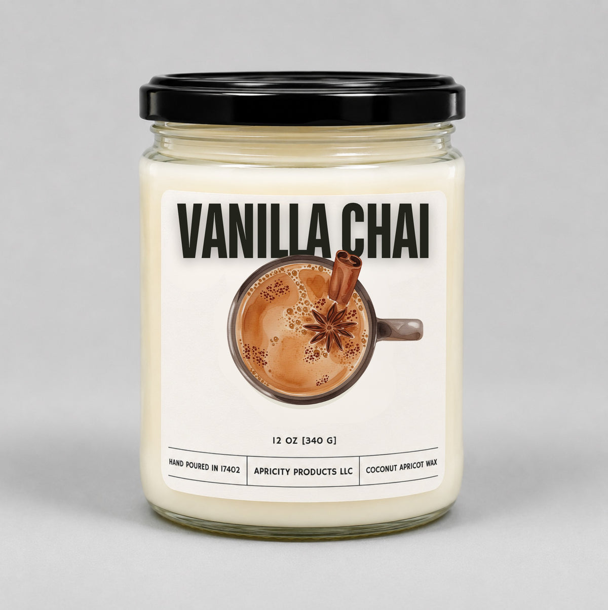 Vanilla Chai 12 oz candle in a clear glass jar with black lid and an illustrated chai latte label