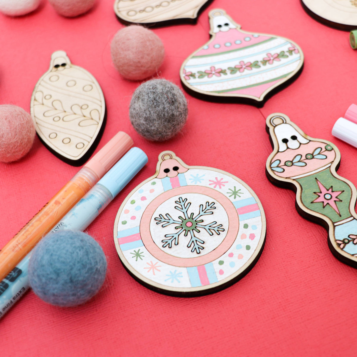 Painted pastel vintage ornament wooden cutouts with felt balls for a DIY Christmas garland