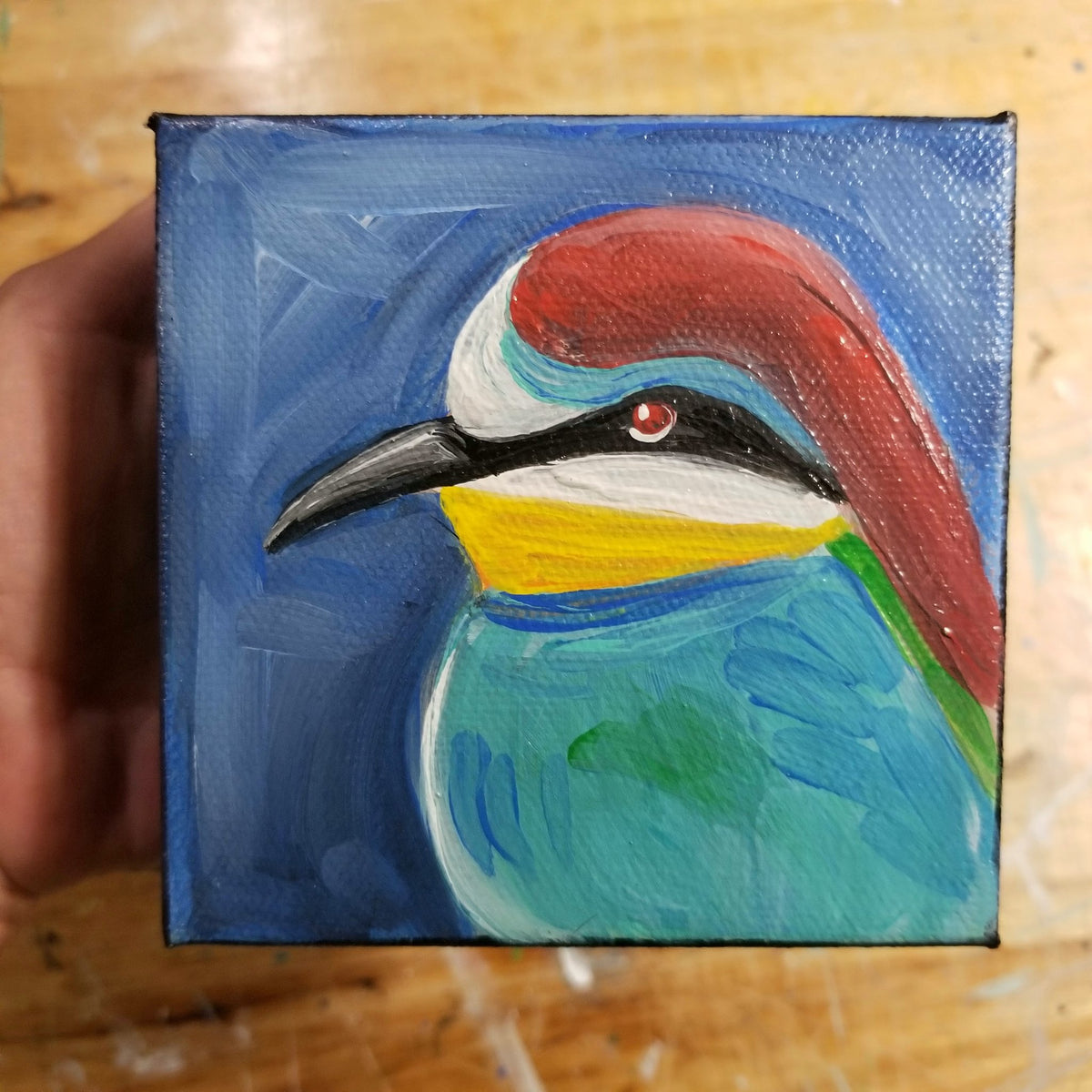 Original small painting of a red headed blue bird on a four inch canvas by Michele The Painter