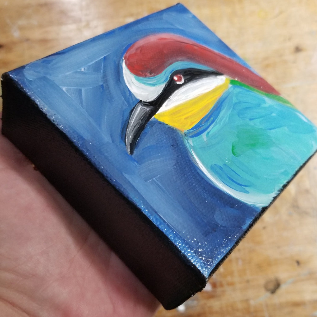 Third view of the red headed blue bird original showing its painted canvas edges