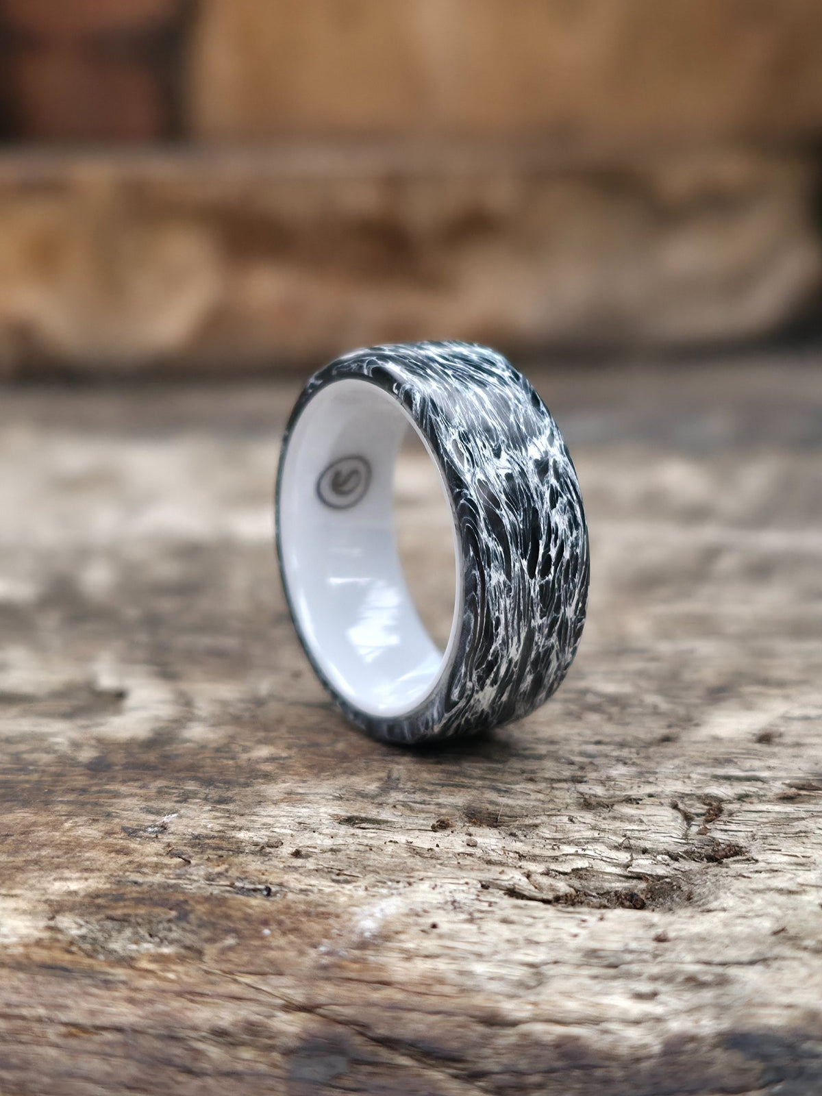 Polar white carbon fiber ring over a white ceramic core by Cameron Senft Designs, size 7