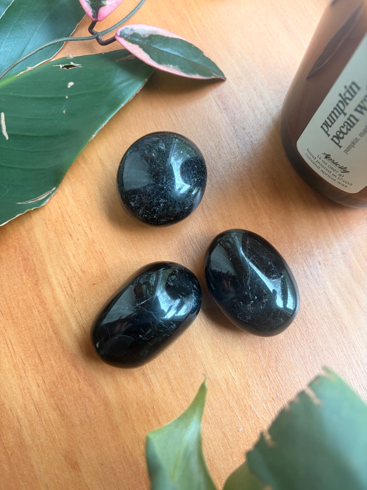 Second view of the black tourmaline palm stone showing its dark polished surface