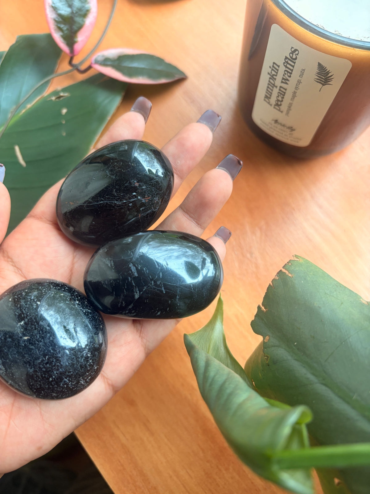 Smooth black tourmaline palm stone, a grounding root chakra crystal from Holistic Unicorn