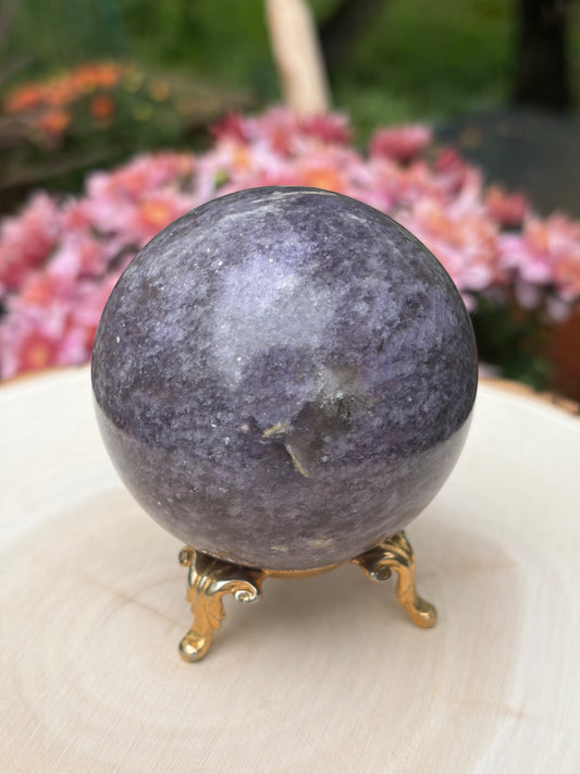 Polished lepidolite sphere from Madagascar displayed on a gold stand, offered by Holistic Unicorn