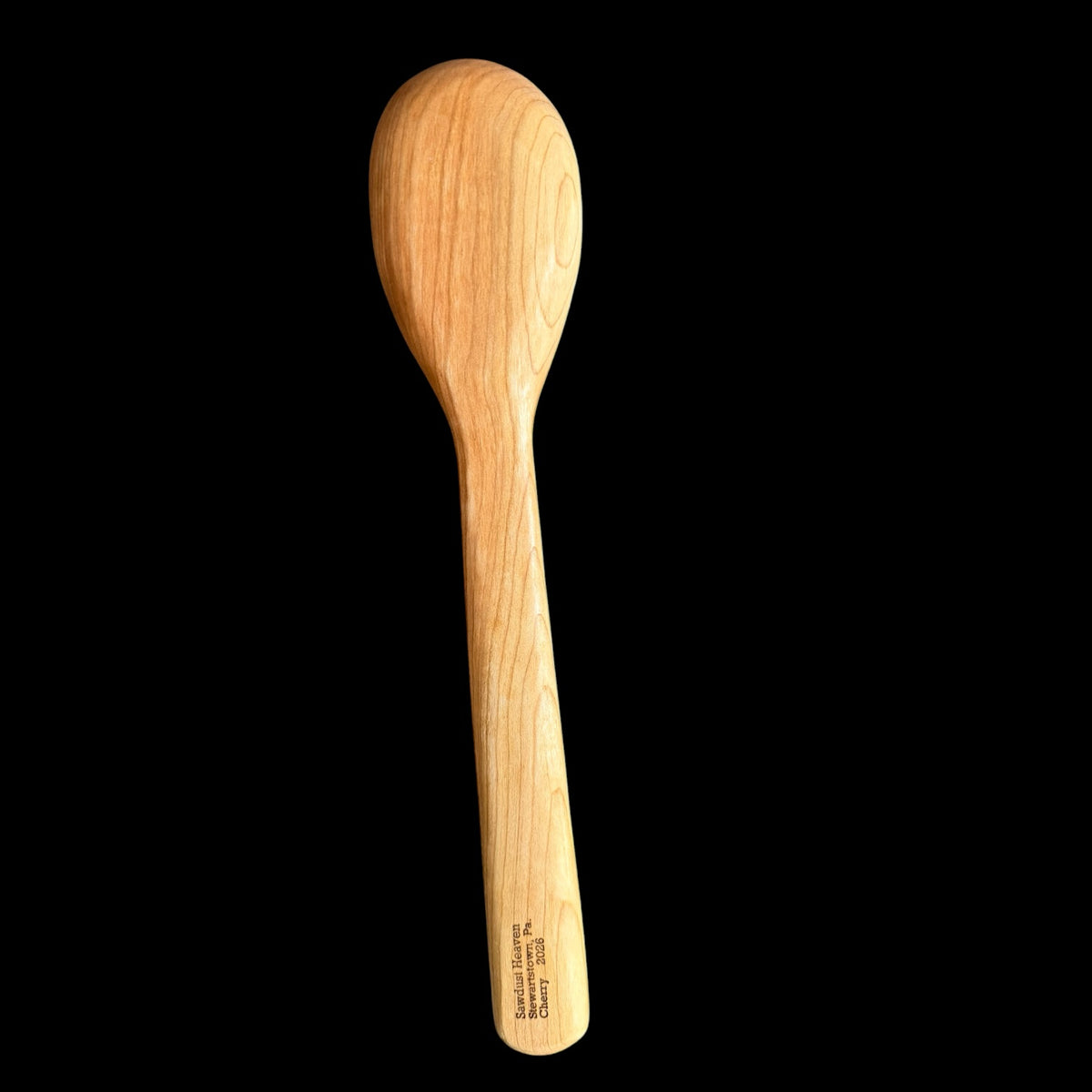 Second view of the carved cherry spoon showing its burnished finish