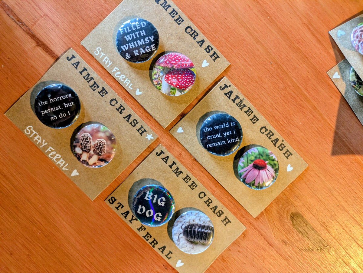 Set of two metal-backed pins featuring whimsical flora and feral fauna with quotes, by Jaimee Crash Art