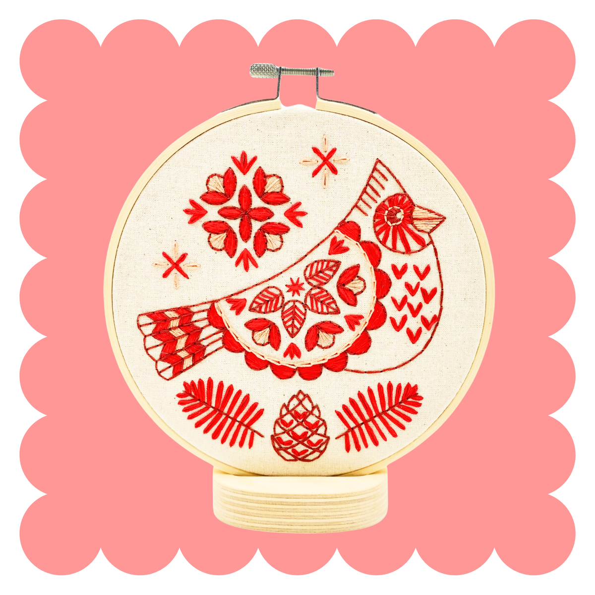 Embroidery hoop with stitched red cardinal in Scandinavian folk style