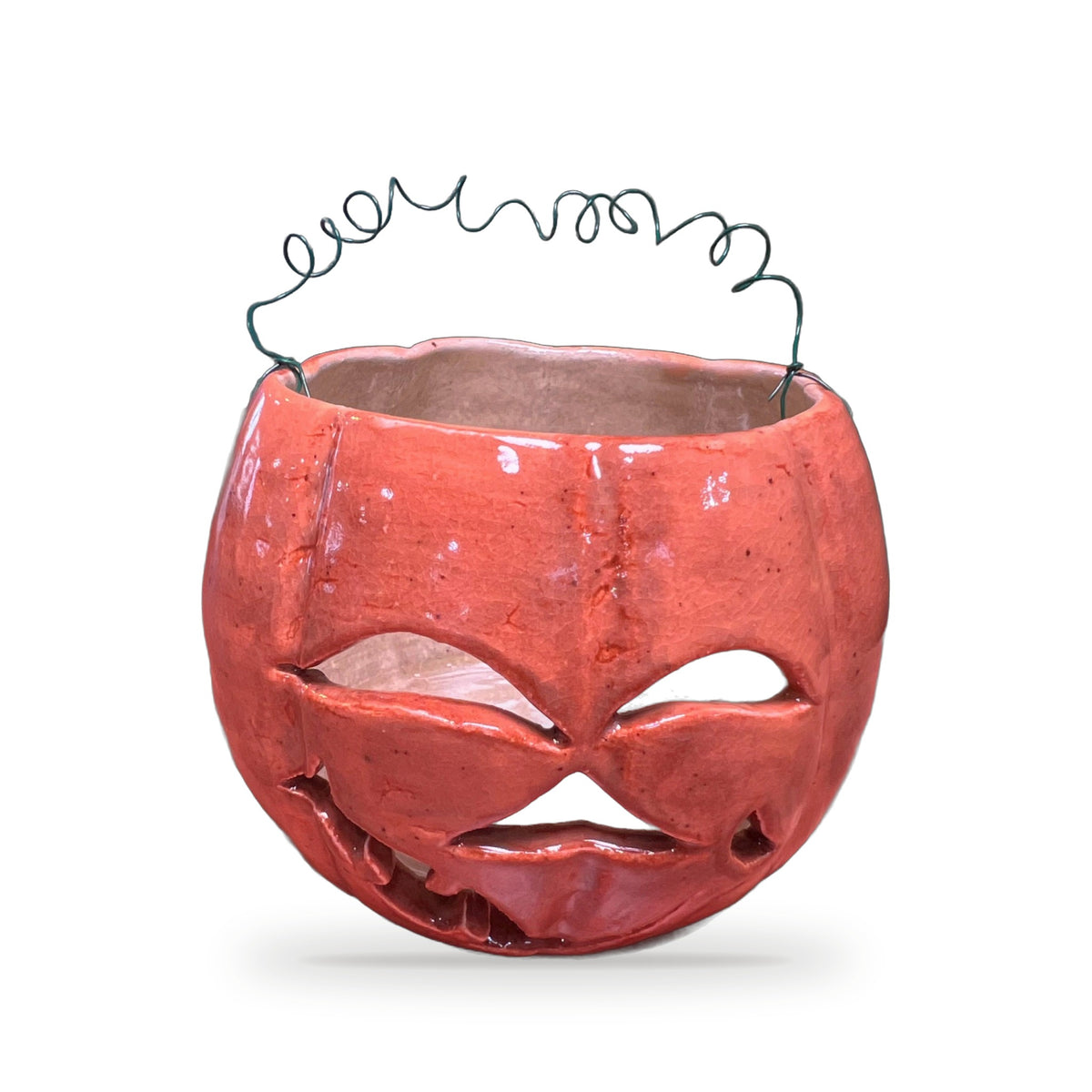 Handmade orange ceramic pumpkin lantern with carved jack-o-lantern face and twisted wire handle by ABeYOUtifulMind