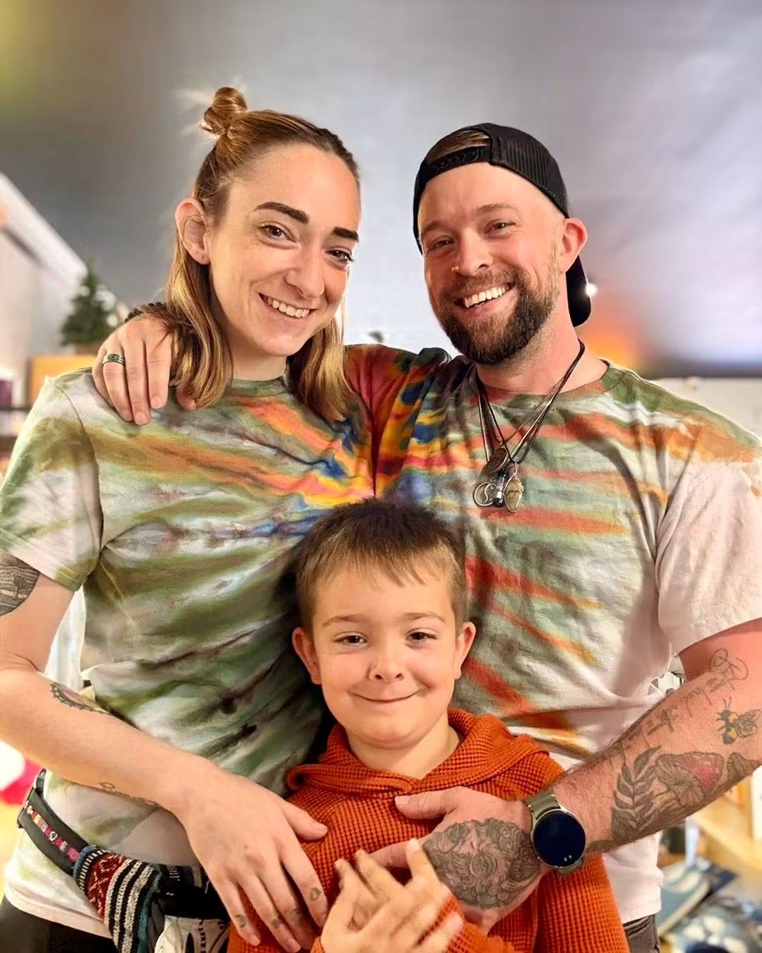 David, Micah and their son Breeze together inside the Apricity Products shop in matching hand-dyed tees