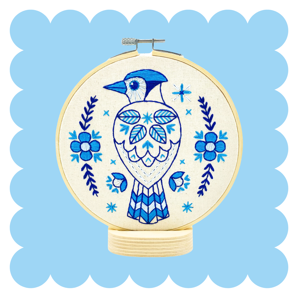 Embroidery hoop with stitched blue jay in Scandinavian folk style