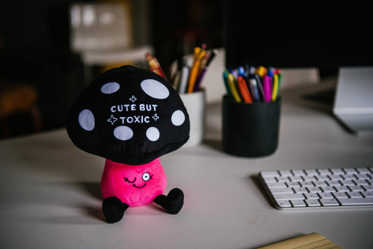Black spotted mushroom plush with pink body and embroidered text Cute But Toxic by Punchkins, view 3