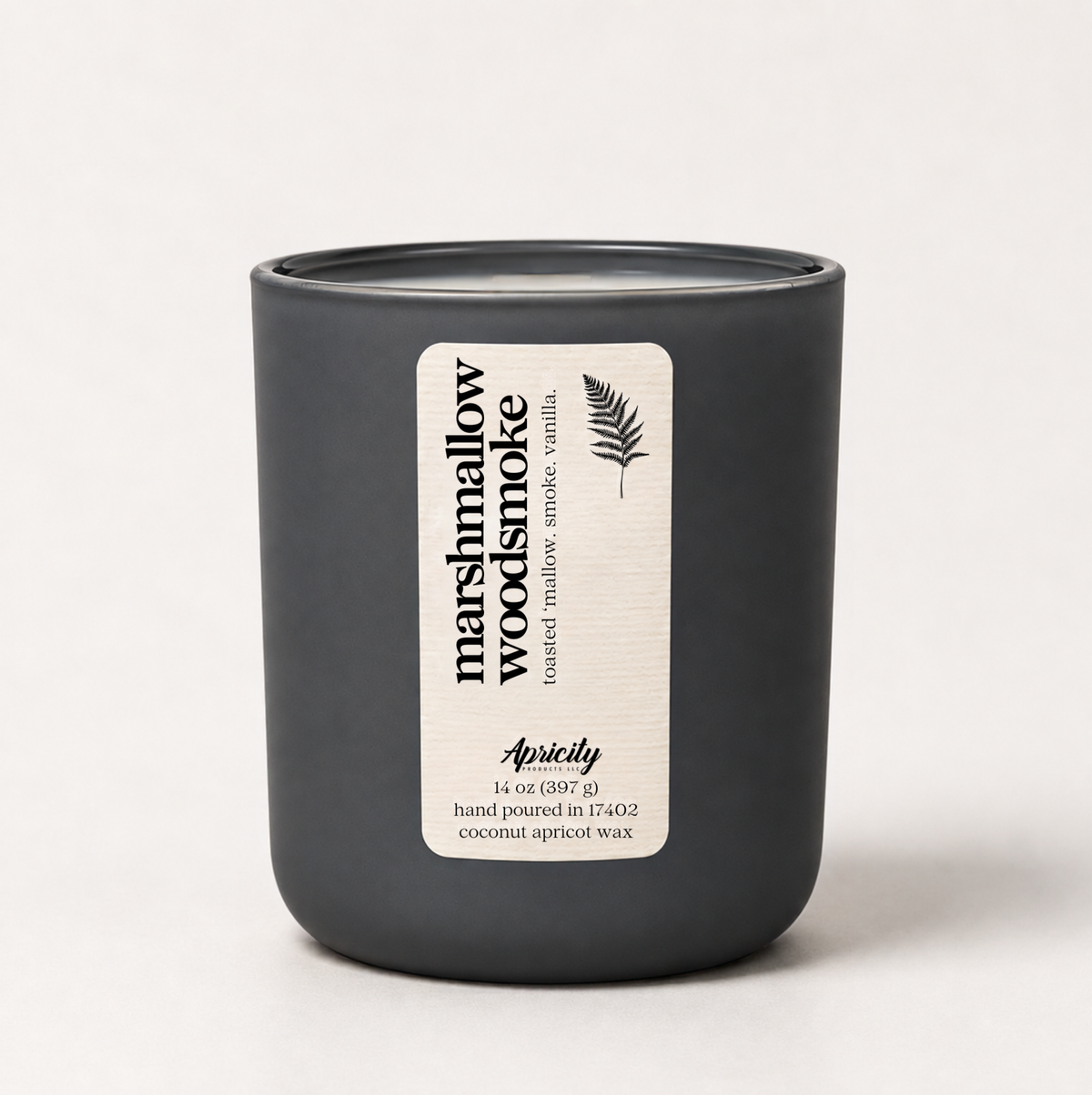 Marshmallow Woodsmoke candle in a matte charcoal vessel with a kraft label